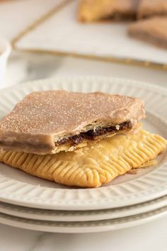 two crackers sitting on top of each other on a plate next to a cup of coffee