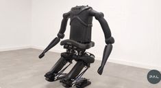 a black robot sitting on top of a white floor