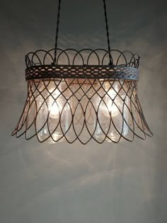 a chandelier made out of wire and glass bottles hanging from it's sides