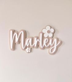 the word marley is made out of wood and has flowers on it's side