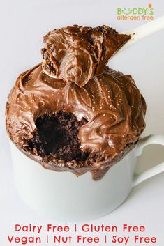 a cupcake with chocolate frosting and a spoon sticking out of it, on top of a white saucer