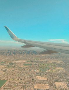 the wing of an airplane flying over a city