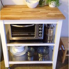 a microwave oven sitting on top of a wooden counter next to a potted plant