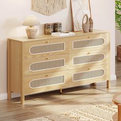 a wooden dresser sitting in a living room next to a wall with pictures on it