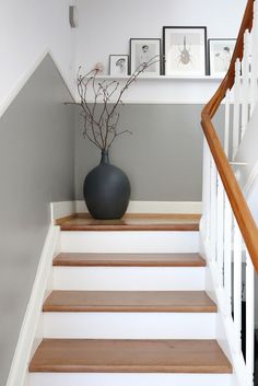 a black vase sitting on top of a set of stairs next to a banister