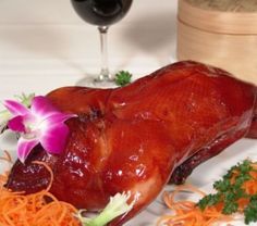 a large piece of meat sitting on top of a white plate next to carrots