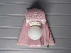 an old fashioned pink phone with a white ball on it's front and back