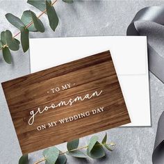 a wooden card with the words to my groom on it and eucalyptus leaves around it