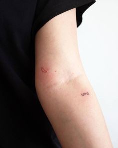 a woman's arm with a small tattoo on the left side of her arm