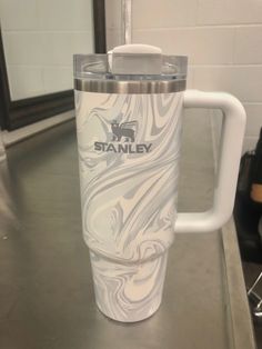 a white marbled tumbler cup sitting on top of a counter