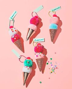 four ice cream cones with pom - poms on them and some tags attached to them