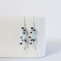 These beautiful and lightweight drop earrings combine wire-wrapped loops with iolite and blue apatite gemstones for a perfect blue and silver color combination that will compliment any silver jewelry in your collection.Silver drop earrings with real gemstones. 100% handmade in the USA in our New York City studio.Earrings are made of .925 sterling silver and have french hooks. (Safety backs are included so you never to worry about them falling off).All of our earrings are meant to be worn with al Blue Wire Wrapped Dangle Earrings, Blue Dangle Earrings Fusion Style, Blue Wire Wrapped Chandelier Earrings, Blue Fusion Dangle Earrings, Blue Wire Wrapped Drop Earrings, Blue Sterling Silver Chandelier Earrings With Ear Wire, Blue Wire Wrapped Dangle Chandelier Earrings, Blue Teardrop Wire Wrapped Chandelier Earrings, Blue Wire Wrapped Dangle Crystal Earrings