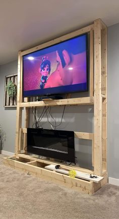 a flat screen tv sitting on top of a wooden shelf