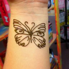 a small tattoo on the wrist of a person with a butterfly in it's hand