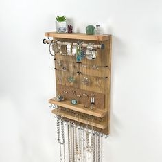 a wooden shelf with several necklaces hanging from it