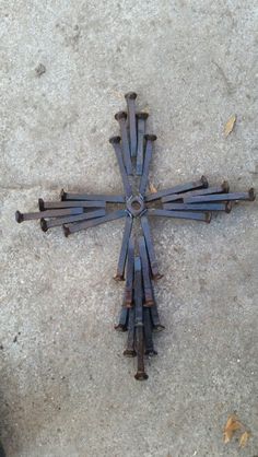 a cross made out of nails laying on the ground