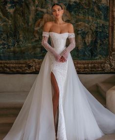 a woman in a white wedding dress posing for the camera