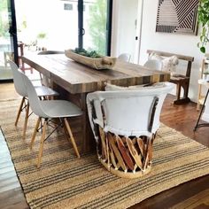 a dining room table with chairs around it and a rug on the floor next to it