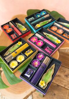 four boxes filled with different types of food on top of a wooden table next to a potted plant