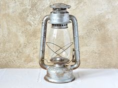 an old fashioned metal lantern sitting on a table