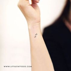 a woman's arm with a small butterfly tattoo on her left wrist and the word love written in cursive writing