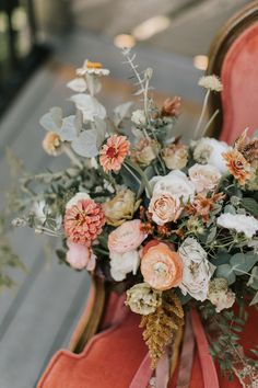 a bouquet of flowers sitting on top of a red chair