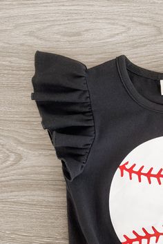 Perfect for warm weather wear Top features ruffle sleeves with a tie waist & a baseball on the front Shorts feature stretch waist & an allover striped print Top and shorts pair for versatility & ease Your little one is going to be the cutest at the ballpark in our Black Striped Baseball Denim Short Set for girls. The black short sleeve top features a fun baseball design on the front and looks adorable paired with the denim shorts. The stretch waistband helps comfort and fit and can be great for Black Spring Playwear Tops, Black Cotton Ruffle Sleeve Top, Black Cotton Tops With Ruffle Sleeves, Stretch Black Tops For Playwear, Black Stretch Tops For Playwear, Baseball Design, Weather Wear, Spandex Shorts, Denim Short