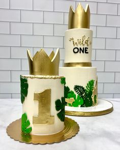 two tiered cake decorated with gold and white frosting, one has the number one on it