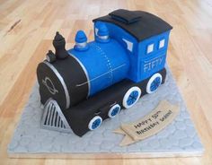 a blue train cake sitting on top of a wooden table