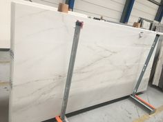 two marble slabs sitting on top of each other in a room with metal racking