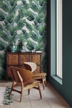 a living room with green wallpaper and wooden furniture