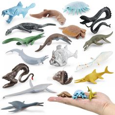 a hand holding a bunch of small toy animals