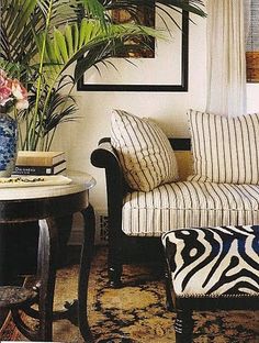 a living room filled with furniture and a zebra print rug on top of a wooden floor