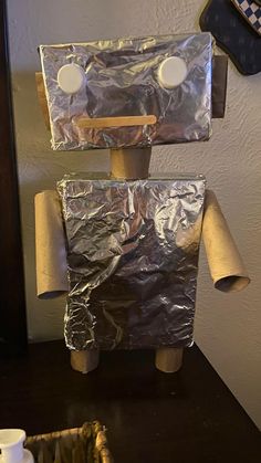 a robot made out of tin foil sitting on top of a table