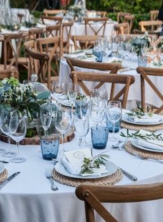 the table is set with many glasses and place settings for guests to enjoy their meal