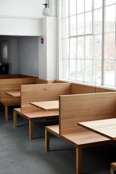 empty tables and benches in a room with large windows