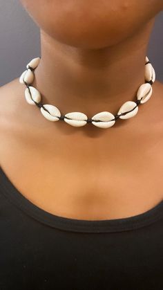 This Cowrie Shell Necklace is our Best Seller! Cowrie shells are known to bring power and good fortune. Our cowrie shell choker necklace is made with all natural cowrie shells and a wax cord. The necklace can be adjusted to your preferred size from 13 -21 inches. Fits children and adults. The necklace is available in a black or beige cord. Automatic Free Shipping on orders over $35! Perfect for a special gift or for yourself. Please read my shop policy before placing your order. Thank you for vi Puka Shells Necklace, Cheap Handmade Shell Beaded Necklaces, Cowrie Necklace, Choker Outfit, African Inspired Jewelry, Cowrie Shell Jewelry, Bellybutton Piercings, Cowrie Shell Necklace, Necklace Shell