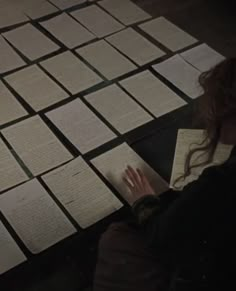 a woman sitting on the floor with papers in front of her