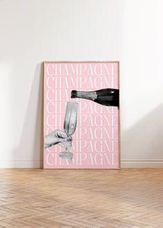 a pink poster with the words champagne and a hand holding a wine glass in front of it