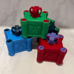 four different colored plastic containers sitting on top of a white countertop next to each other