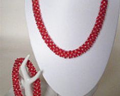 "This Ruby Red and Silver Lined Delica Bead Necklace and Bracelet Set is perfect for the Lady who loves to wear Black, Navy or White anytime of year. This set is handmade from Delica Japanese Beads in a Rope style and is finished off with handmade Loop & Toggle Clasps. You may join the Bracelet and Necklace when the clasps become a feature. The total length is then 28\" or 77cm. The Necklace alone measures almost 20\" or 51 cm. The Bracelet measures 9\" or 23cm. Soft and slightly stretchy th Red Beaded Bracelets With Spacer Beads For Party, Red Spacer Beads Jewelry For Party, Red Beaded Bracelets With Round Beads For Wedding, Red Round Beaded Bracelets For Wedding, Red Hand-strung Necklace For Wedding, Ruby Red Necklace, Japanese Beads, Necklace And Bracelet Set, Christmas Labels