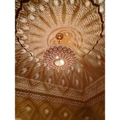 the ceiling light is shining brightly in the room with intricate designs on its glass dome