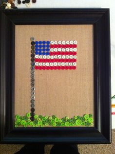 a person holding up a framed art piece with buttons on the bottom and an arrow in the middle