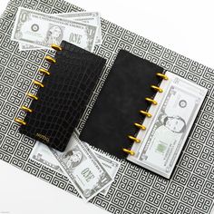 a black and gold notebook with money on it