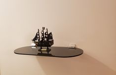 a glass shelf with a model ship on it