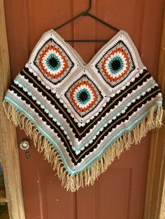 a crocheted blanket hanging on a door