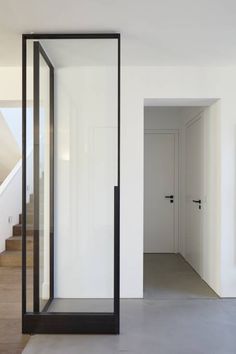 an empty room with white walls and black framed glass doors on either side of the door