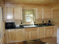 a kitchen with wooden cabinets and black counter tops