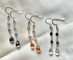 These cute teardrop glass dangling earrings make perfect gifts for the minimalist or if you are one yourself.  They add just a little flair to your wardrobe.  Each teardrop earring is glass, the accent beads are made of genuine gemstone, czech firepolish beads or glass beads (see description per earring) -Sterling Silver fishook backing -Teardrop glass beads - Dark Blue, Light Blue, Orange -4mm sapphire beads -4mm czech firepolish beads -4mm pacific blue luster firepolish bead -4mm dark blue glass beads -4mm opaque cream glass beads -4mm transparent topaz glass beads -Total length 2 & 1/4" Silver Teardrop Crystal Earrings For Everyday, Everyday Silver Teardrop Crystal Earrings, Handmade Teardrop Crystal Earrings For Everyday, Handmade Everyday Teardrop Crystal Earrings, Everyday Handmade Teardrop Crystal Earrings, Minimalist Teardrop Crystal Earrings With Ear Wire, Silver Minimalist Teardrop Crystal Earrings, Flower Pressing, Sapphire Beads