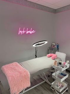 a pink neon sign above a bed in a room